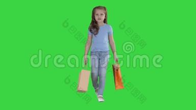 带着购物袋走在绿色屏幕上的小女孩，Chroma键。